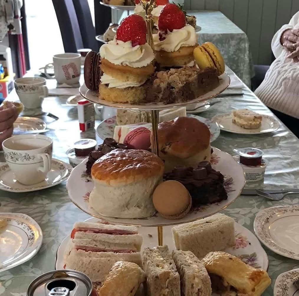 A full afternoon tea stand with sandwiches, scones and cakes at the Gardeners Rest