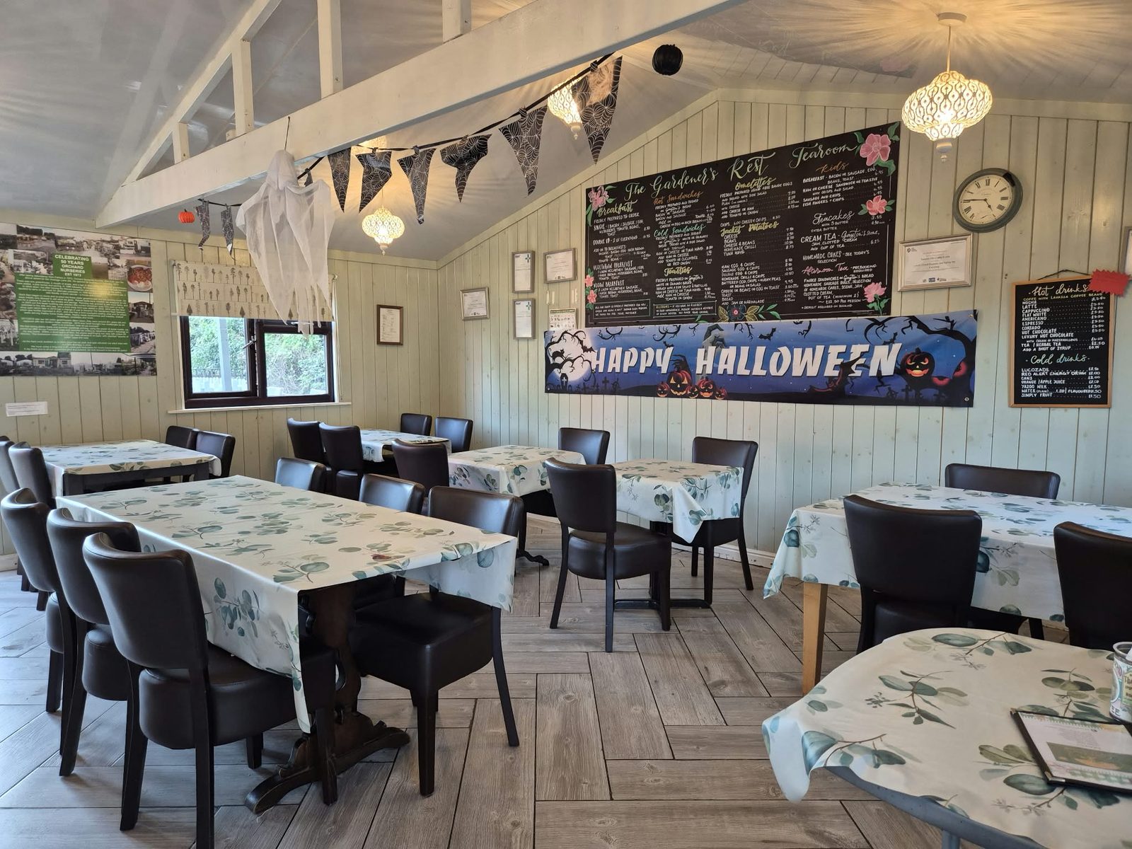Inside the Gardeners Rest Tearooms, with tables laid and the famous chalkboard menu on the wall