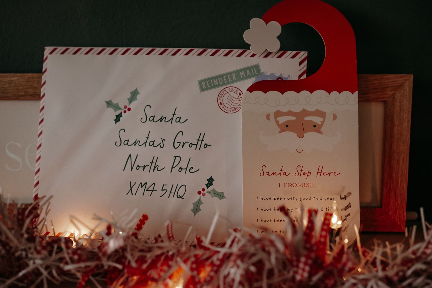 A letter to Santa surrounded by fairy lights and festive greenery